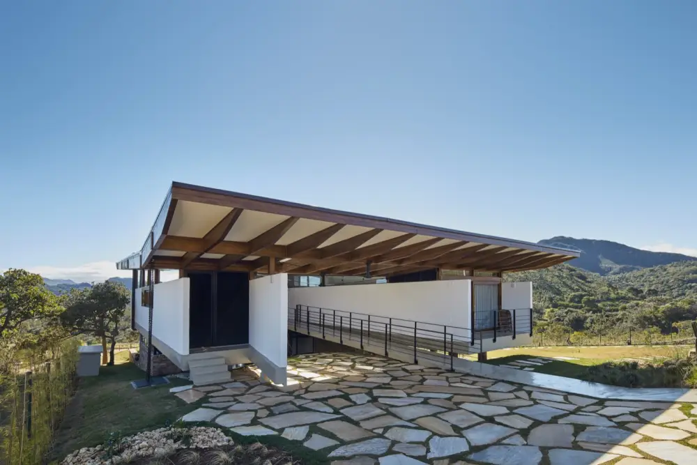 Residência com cobertura em estrutura de madeira laminada colada e vista para a serra