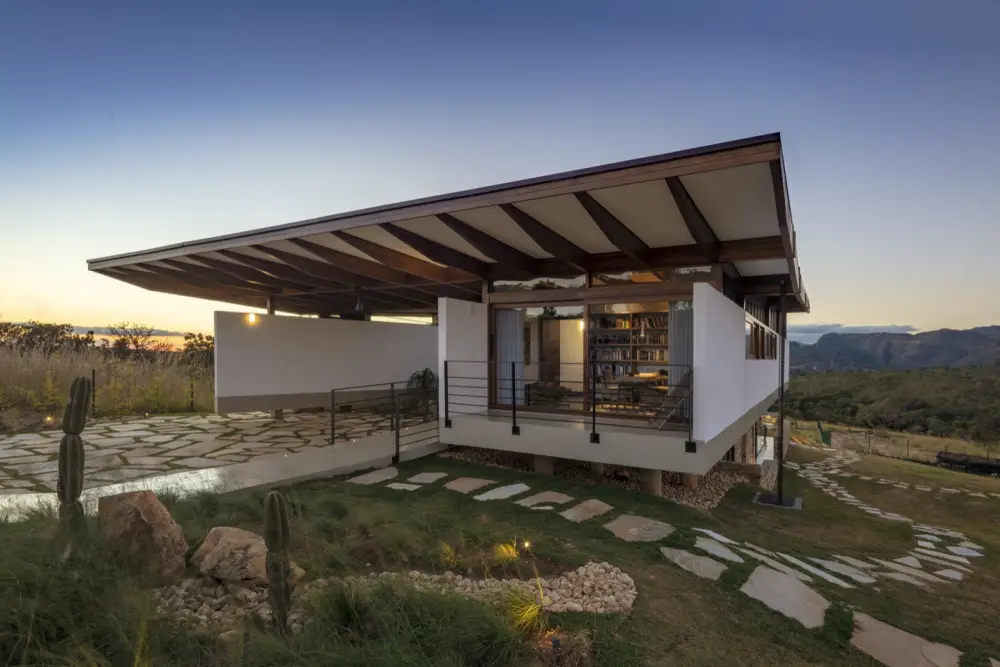Casa em estrutura de MLC ao entardecer com beiral amplo