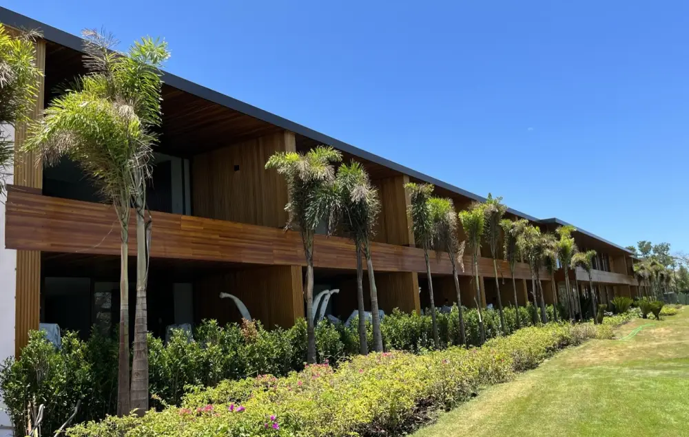 Edifício de hospedagem com fachada e estrutura em madeira e jardim paisagístico